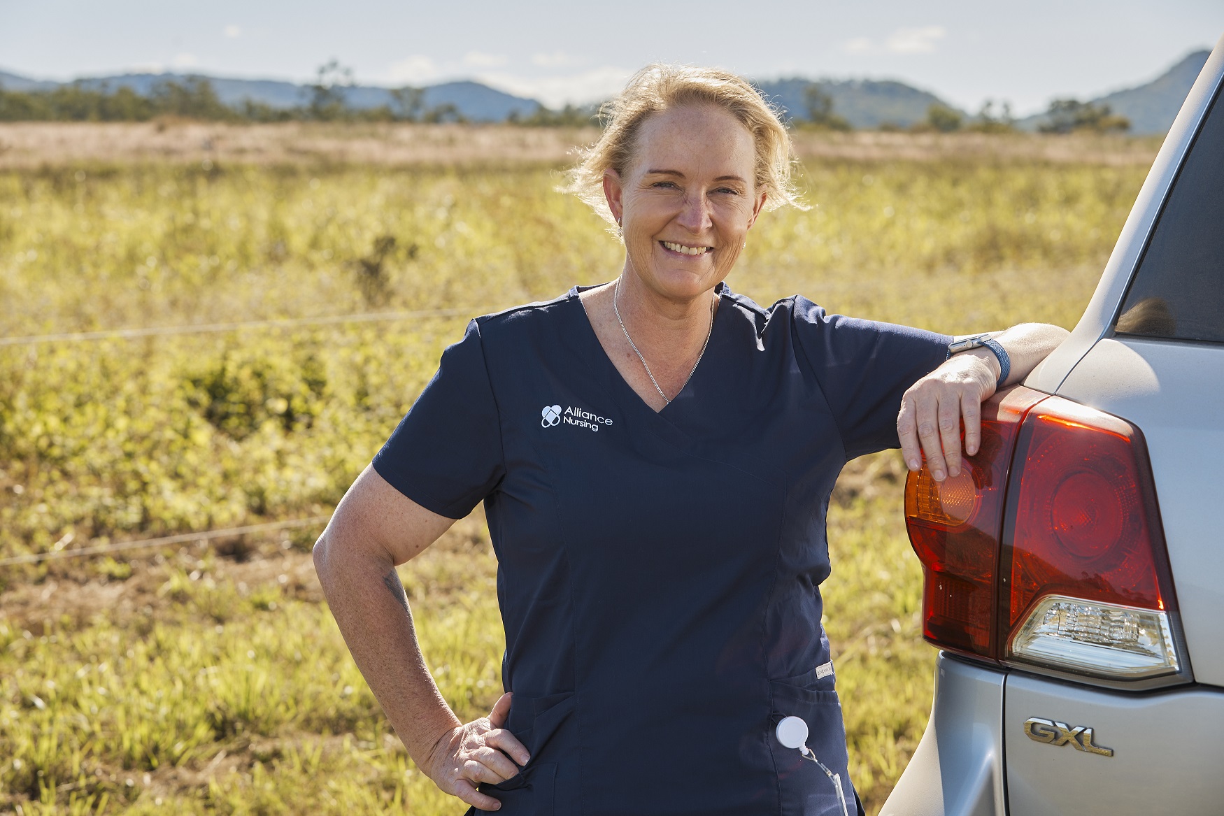 Nurse leaning on car in the outback