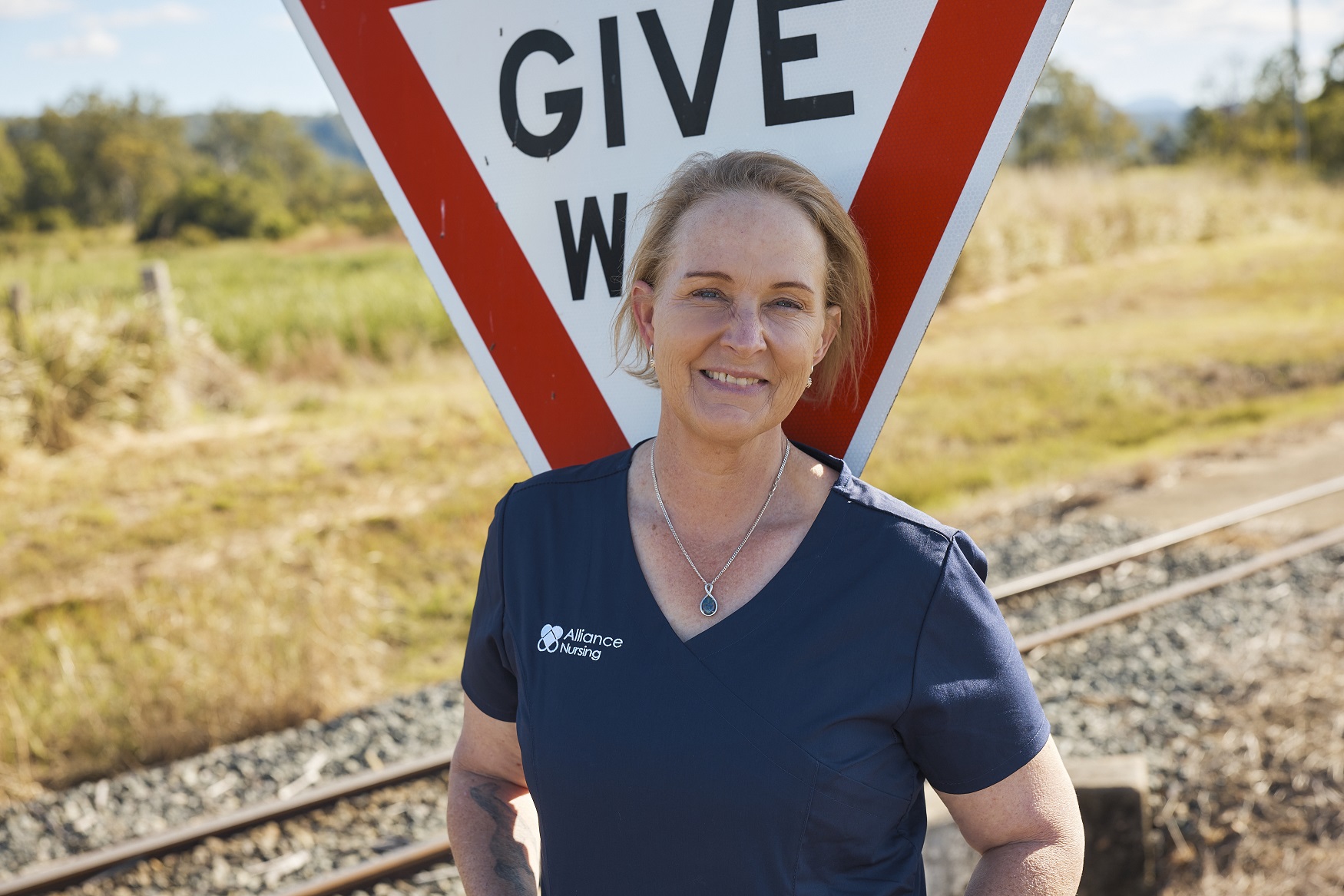 Nurse smiling near give way sign